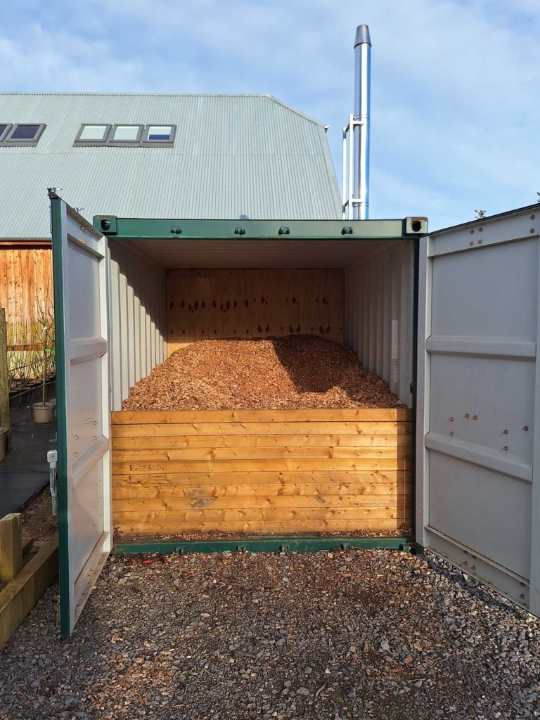 View into the open heating container of Oxfordshire garden centre, United Kingdom | Reference Hargassner wood chip boiler